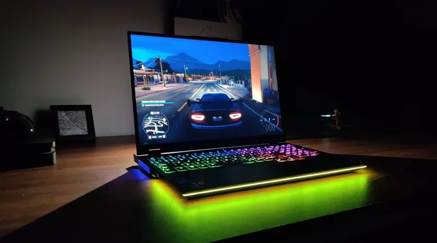 نمایش بازی ماشینی روی صفحه نمایش لپ تاپ لنوو مدل Legion 7 با کیبورد RGB روی میز چوبی